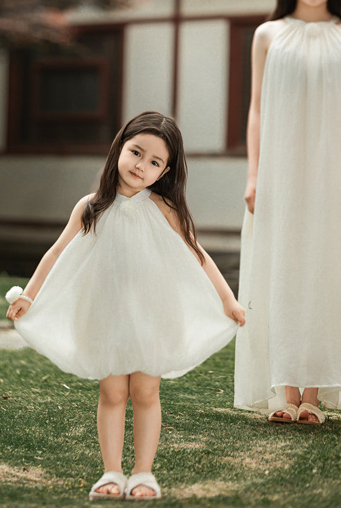 girl wearing summer dress with halter neck and elegant floral accent outdoor