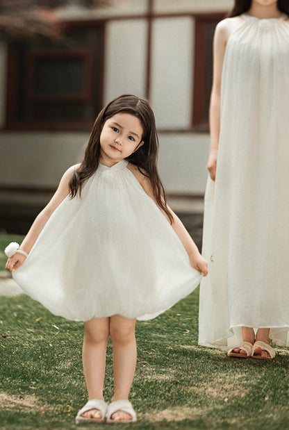 girl wearing summer dress with halter neck and elegant floral accent outdoor
