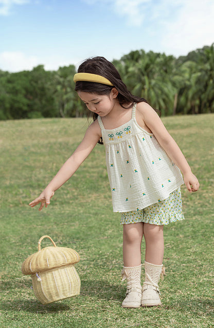 Young girl in a white top with cherry embroidered patterns by Ava & Bear London
