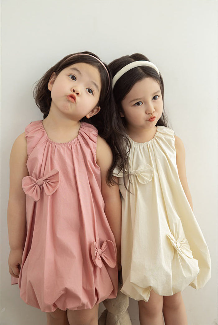 girls wearing elastic neckline dress with bow details