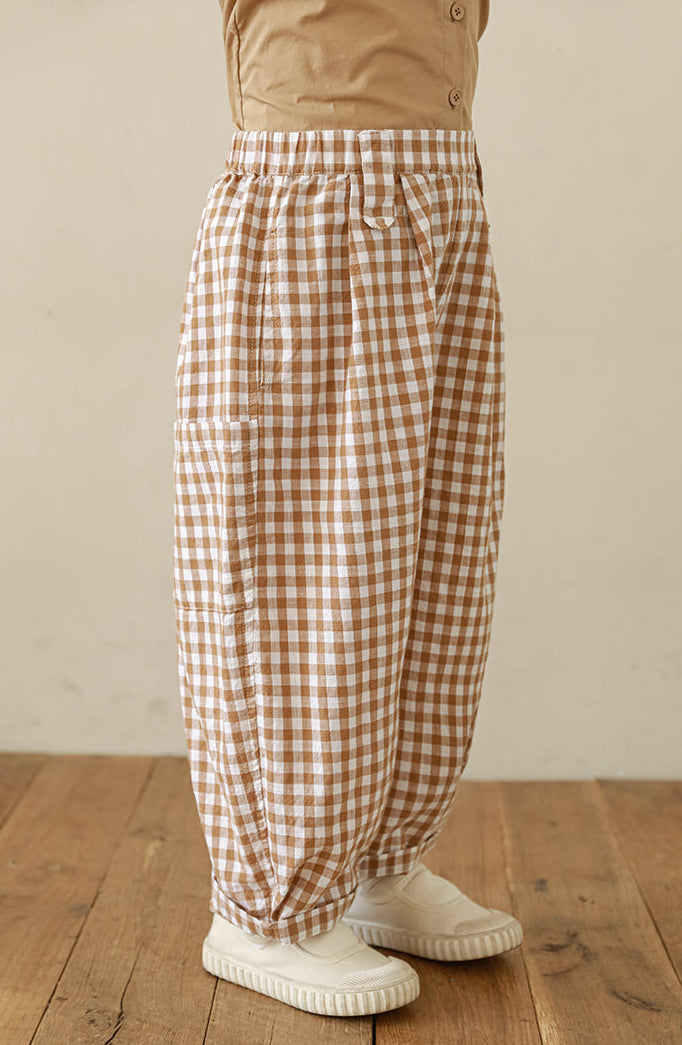 Side view of Ava & Bear London girls’ pleated cotton trousers in gingham print
