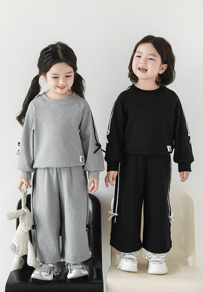 Girls wearing grey sweatshirt and joggers set with ribbon detailing